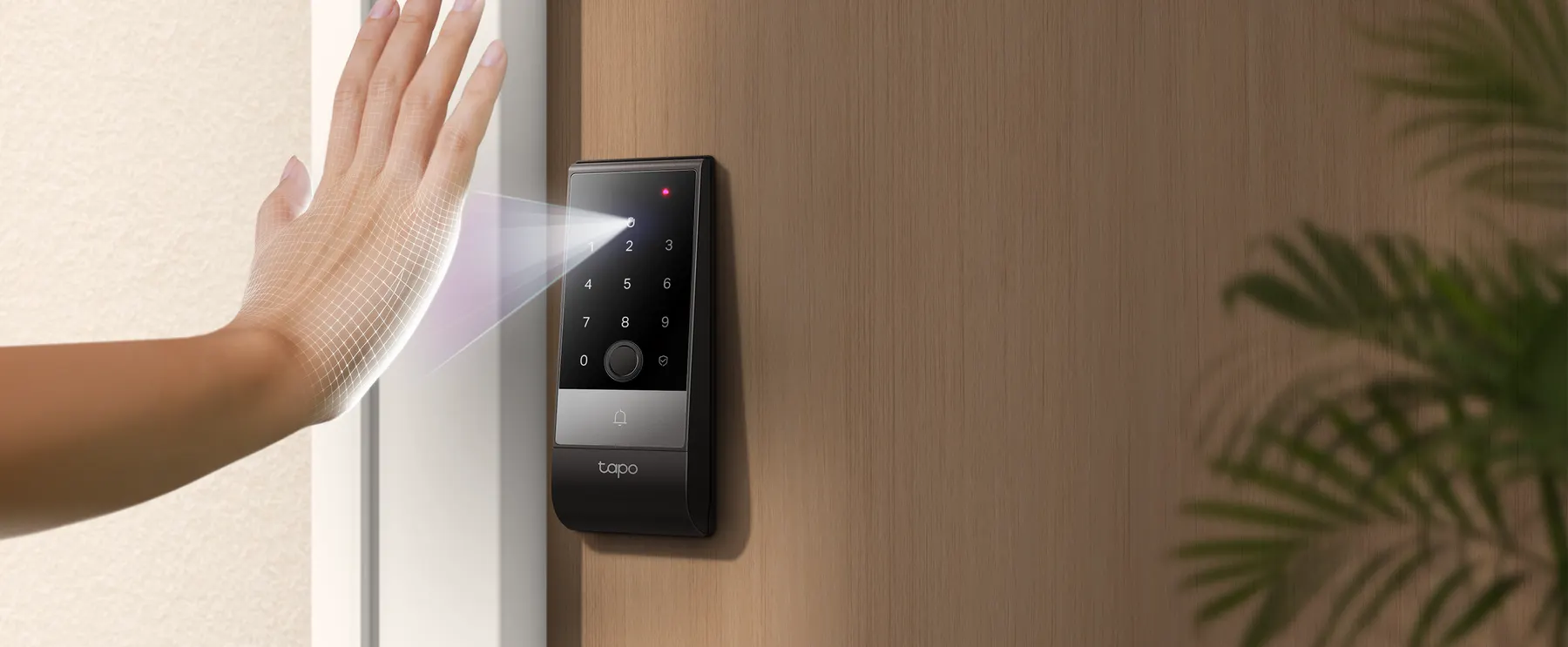 A hand held up to the palm sensor of the Tapo DL130 smart lock mounted beside a wooden door